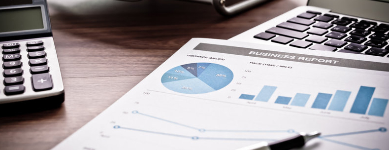 Business report next to adding machine